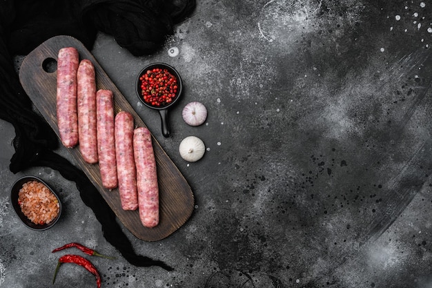 Saucisse crue pour friture, sur fond de table en pierre noire noire, vue de dessus à plat, avec espace de copie pour le texte