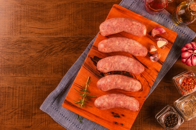 Saucisse de cuisse de porc brésilien à l'ail sur une planche à découper en bois isolé sur bois