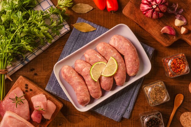 Saucisse de cuisse de porc brésilien sur plaque blanche avec des épices et des ingrédients