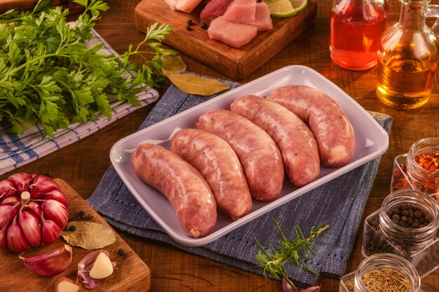 Saucisse de cuisse de porc brésilien sur plaque blanche avec des épices et des ingrédients