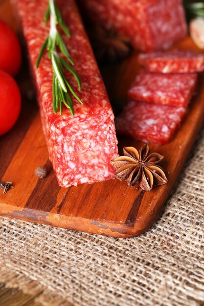 Saucisse et épices salami savoureuses sur le fond en bois