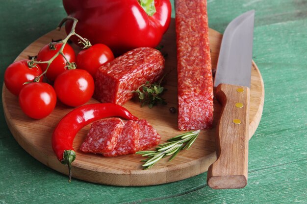 Saucisse et épices savoureuses de salami sur la table en bois