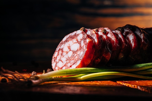 Saucisse fumée crue hachée sur fond sombre sur une surface en bois