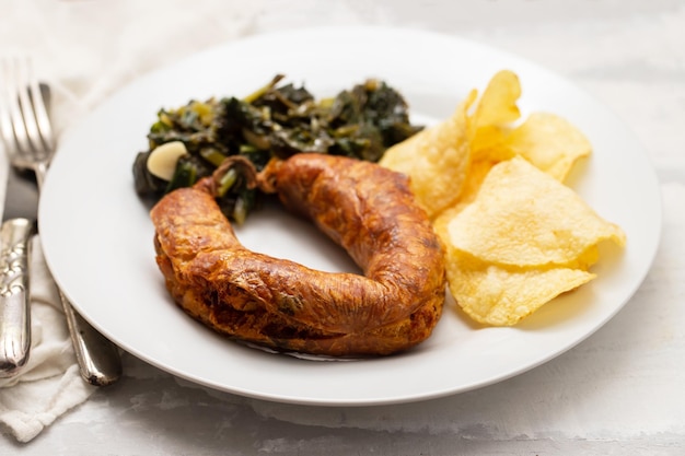 Saucisse fumée portugaise typique frite avec frites et épinards