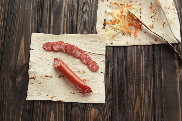 Saucisse maison avec pain pita sur fond de bois