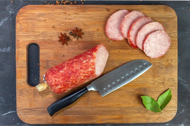 Saucisse maison sur une vue de dessus de planche à découper. Morceaux de cervelat