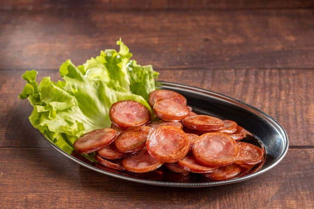 Saucisse de pepperoni frite coupée en tranches sur la plaque