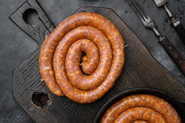 Saucisse de porc en spirale saucisse Cumberland sur fond de table en pierre noire vue de dessus mise à plat