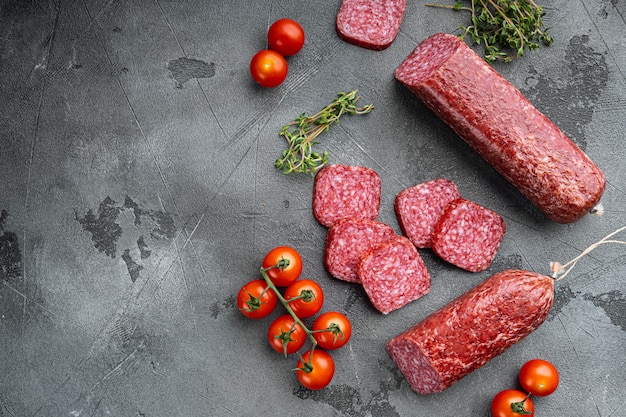 Saucisse de salami fumé traditionnel aux épices, sur table en pierre grise, vue de dessus à plat