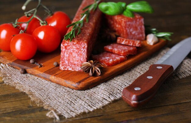 Saucisse de salami savoureuse et épices sur table en bois