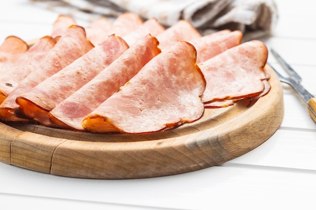 Saucisse de salami en tranches Jambon fumé sur table blanche