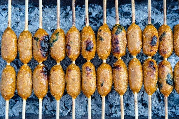 Saucisse thaïlandaise grillée au marché de l'alimentation de rue en Thaïlande gros plan Saucisse thaïlandaise traditionnelle avec du porc et du riz délicieux aliments de rue