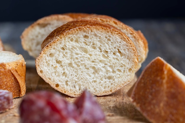 Saucisse tranchée avec une baguette sur une planche de bois