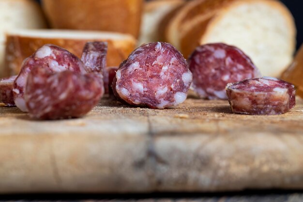 Saucisse tranchée avec une baguette sur une planche de bois