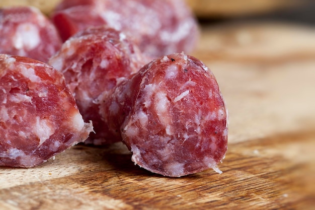 Saucisse tranchée de viande séchée avec bacon, morceaux de viande séchée sur une planche à découper