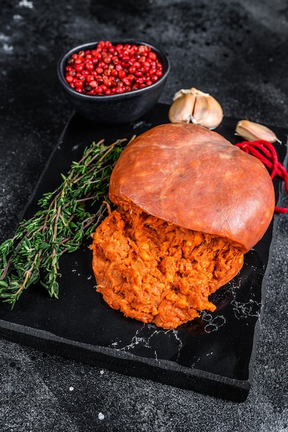 Saucisse de viande séchée Sobrassada des Baléares à base de porc haché, paprika et épices Fond noir. Vue de dessus.