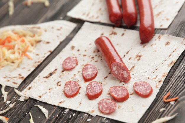 Saucisses au chou mariné et pain pita sur fond de bois