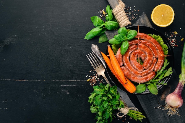 Saucisses barbecue frites avec des légumes frais Sur un fond en bois Vue de dessus Espace de copie