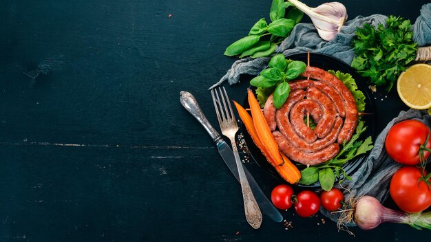 Saucisses barbecue frites avec des légumes frais Sur un fond en bois Vue de dessus Espace de copie