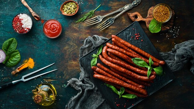 Saucisses de chasse fumées sur une plaque en pierre noire Vue de dessus Espace de copie gratuit