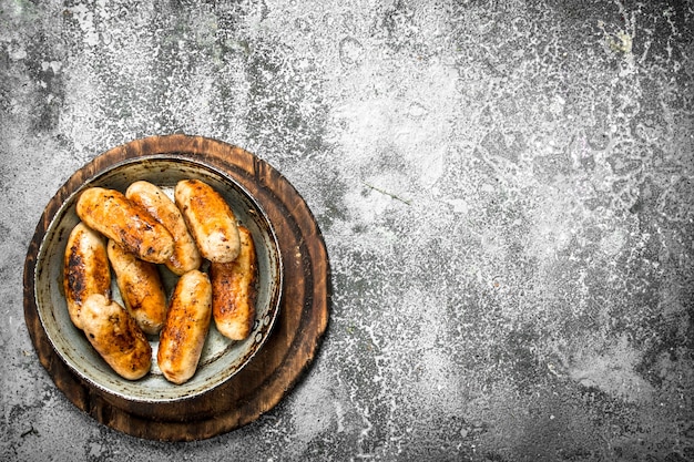 Saucisses chaudes dans une poêle sur un fond rustique