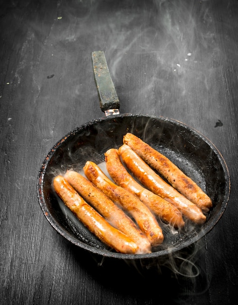 Saucisses Chaudes Dans Une Poêle. Sur Le Tableau Noir.