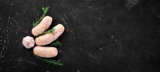 Saucisses crues aux épices et herbes Barbecue Sur fond de pierre noire Vue de dessus Espace de copie gratuit