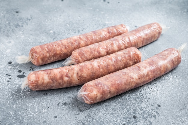 Saucisses crues Bratwurst sur une table de cuisine. Fond gris. Vue de dessus.