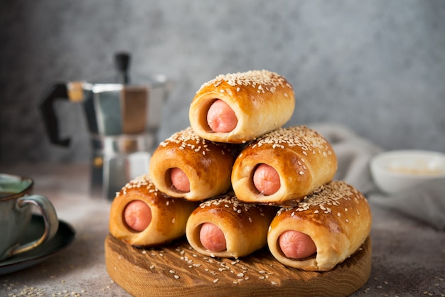 Saucisses faites maison en pâte sur une planche de bois, restauration rapide, gros plan