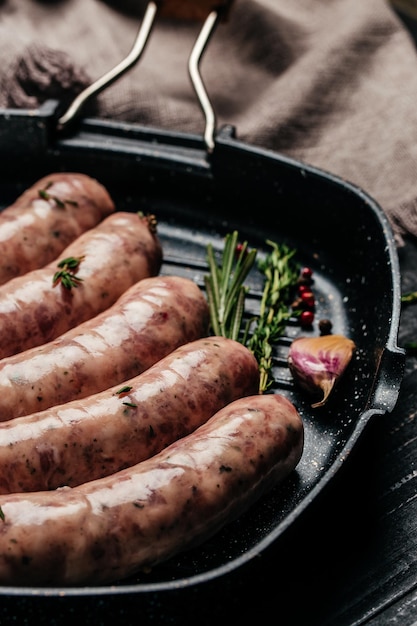 Saucisses farcies crues sur srill pan, ingrédients de cuisine. image verticale. vue de dessus. place pour le texte