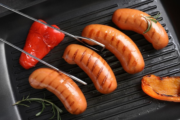 Photo saucisses frites sur une lèchefrite