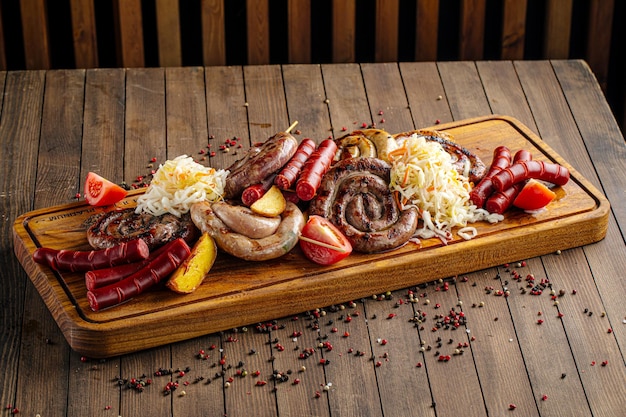 Saucisses grillées assorties placées sur la planche de service