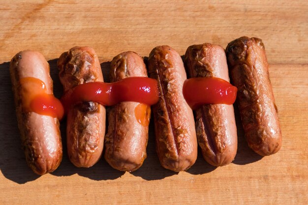 Saucisses grillées au ketchup sur planche de bois