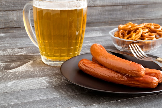 Saucisses grillées à la bière sur une table en bois.