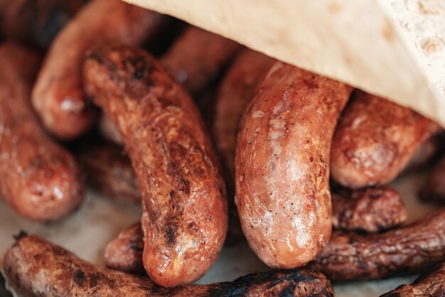 Saucisses grillées ou bratwurst sur grill avec fumée et flamme