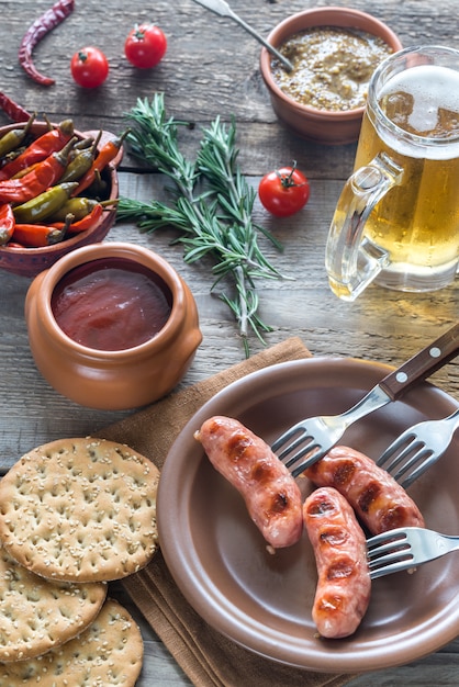 Saucisses grillées avec entrées et chope de bière