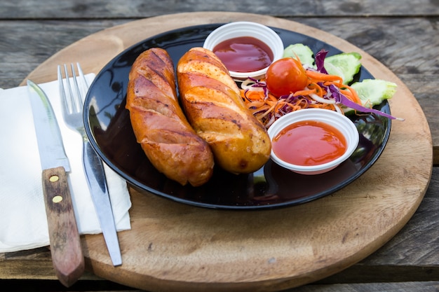 saucisses grillées et légumes dans un plat noir