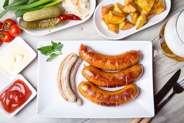 Saucisses Grillées Avec Pommes De Terre, Concombres Et Choucroute, Avec Deux Sauces.