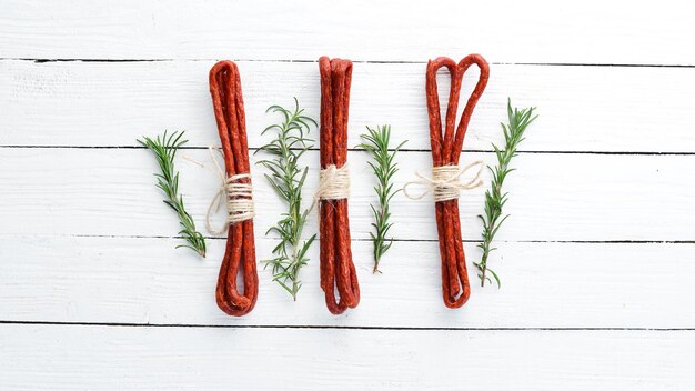 Saucisses Kabanosi Sur un fond en bois blanc Vue de dessus Espace de copie gratuit