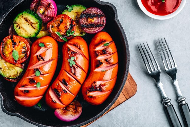 Saucisses et légumes grillés dans une poêle en fonte Vue de dessus