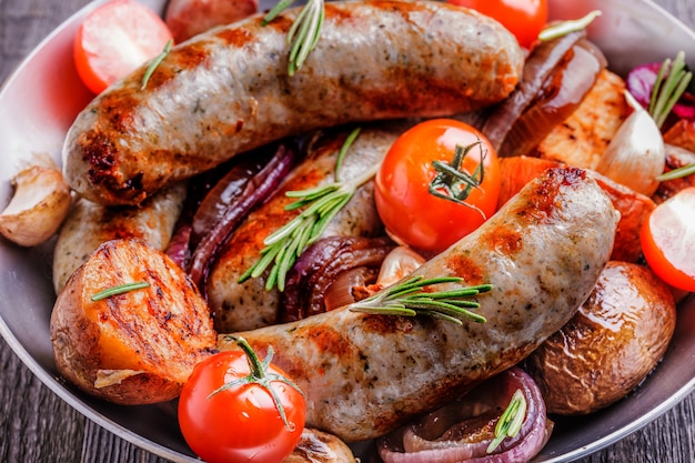 Saucisses et légumes grillés dans un style rustique.