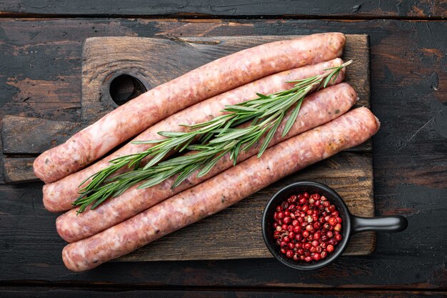 Saucisses mest traditionnelles, à plat, sur la vieille table en bois sombre.