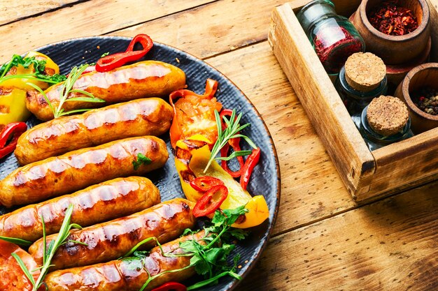 Saucisses de porc grillées sur l'assiette. Saucisses et légumes frits