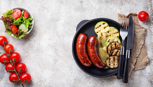 Saucisses de porc grillées et légumes