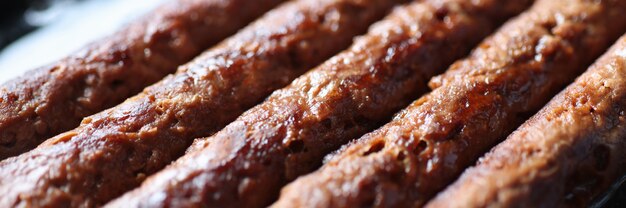 Les saucisses de porc sont frites dans une casserole en gros plan