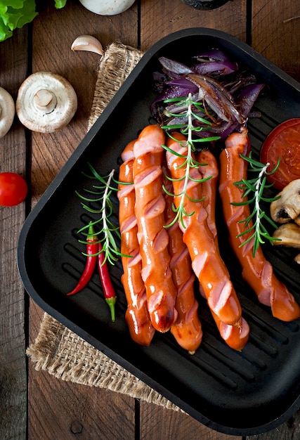 Saucisses sautées aux légumes sur une plaque blanche