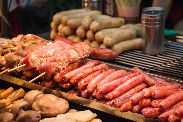 Photo saucisses taïwanaises grillées, champignons enoki de porc et champignons