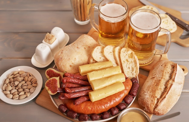 Photo saucisses et tranches de fromage avec bière légère et pistaches pour l'oktoberfest