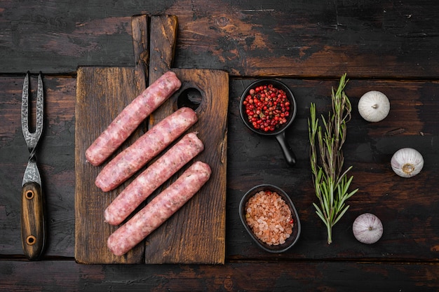 Saucisses de viande hachée sur une vieille table en bois sombre fond vue de dessus mise à plat