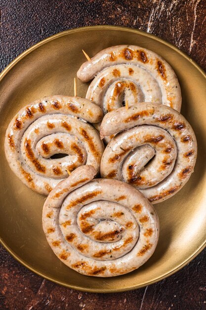 Saucisses de viande de porc rôties bavaroises en spirale aux herbes Fond sombre Vue de dessus